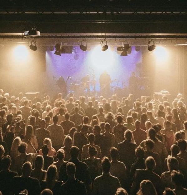 Een volle concertzaal, op het podium treed er een band op